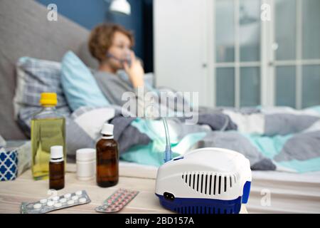 teenager girl doing inhalation indoor , Young woman doing inhalation with a nebulizer at home Stock Photo