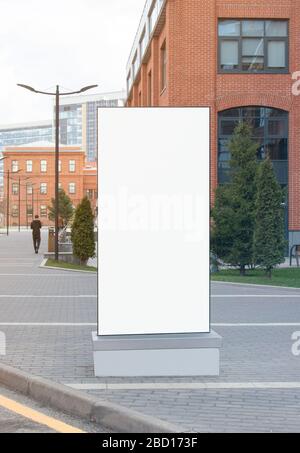 Blank white vertical pylon stand mock up brick building background Stock Photo