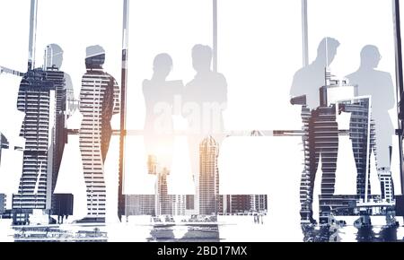 Silhouettes of people against the window. A team of young businessman working and communicating together in an office. Corporate business team and Stock Photo