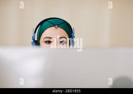 Young muslim woman with beautiful eye make-up working on computer in office Stock Photo