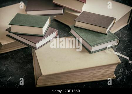 Several different sizes of books close up on a dark background, selective focus. Concept of back to school, education, reading time Stock Photo