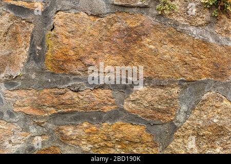 Stone wall. Rough texture. Stones connected with concrete. Gray joints. Old church wall. Stock Photo
