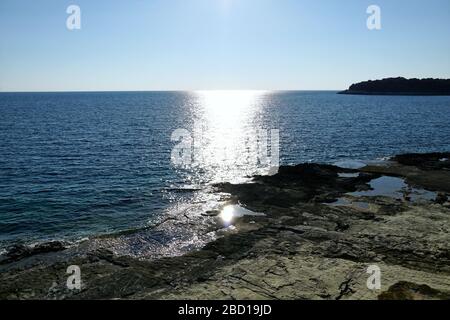 Sparkling light trail on the blue sea surface when sunlight reflects from seawater and small waves Stock Photo