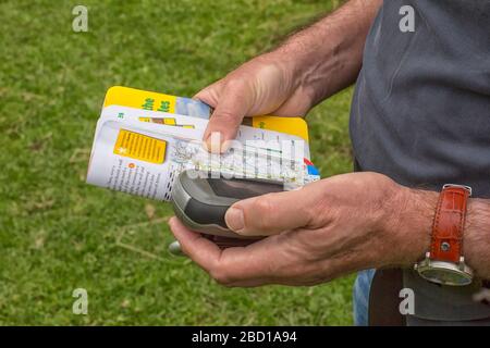 Man holding a GPS receiver and plan in his hand. Handheld GPS devices are used predominantly in the outdoor leisure industry for walking and hiking. Stock Photo