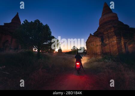 Tourist Visiting Myanmar - Young Woman exploring city of Bagan on electric scooter Stock Photo