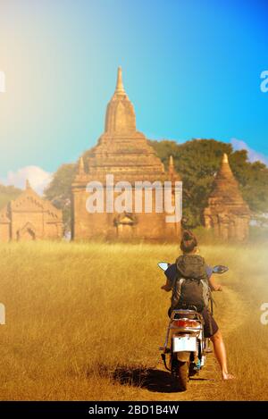 Tourist Visiting Myanmar - Young Woman exploring city of Bagan on electric scooter Stock Photo