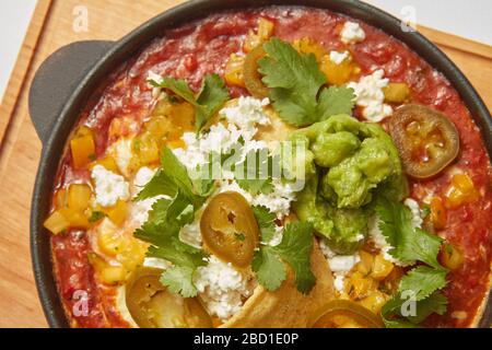 Close up view of Shakshuka dish in a pan with spicy sauce from tomatoes. Stock Photo
