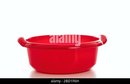 Cleaning wash bowl, plastic hand basin red color isolated against white background, Domestic household cleaning Stock Photo
