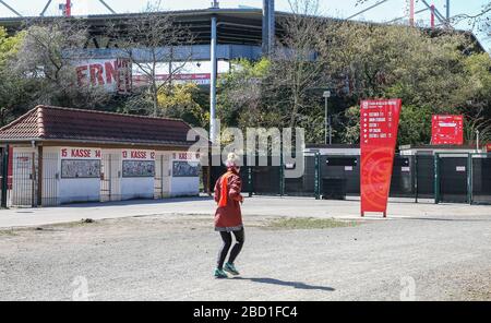 Berlin, Germany. 06th Apr, 2020. A jogger runs past the closed area of the stadium 'An der Alten Försterei'. Union Berlin will start training in groups of two, excluding the public. Credit: Andreas Gora/dpa/Alamy Live News Stock Photo