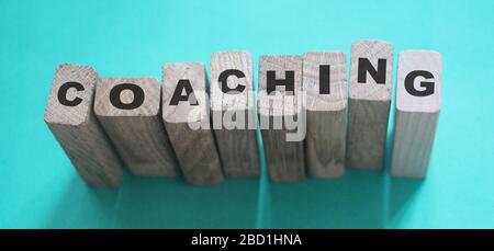 Coaching word on wooden blocks on aqua blue background. Personal and business achievements concept Stock Photo