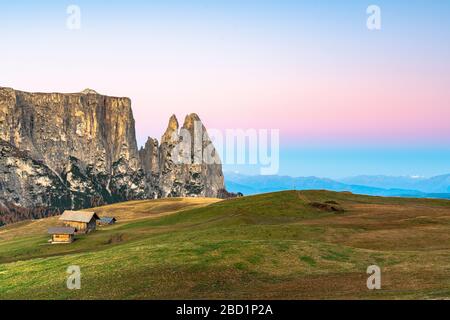 Autumn sunrise over Sciliar peaks and wood huts at Alpe di Siusi (Seiser Alm), Dolomites, South Tyrol, Italy, Europe Stock Photo