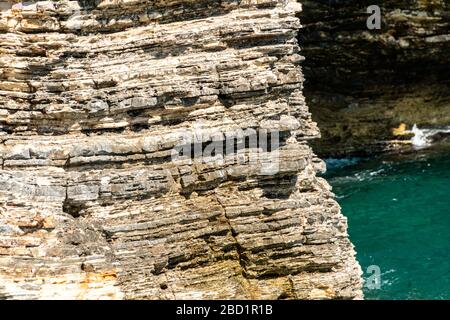 background and texture of mountain layers and cracks in sedimentary rock on cliff face. Cliff of rock mountain. Stock Photo