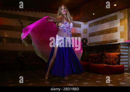 Beirut, Lebanon - May 30, 2017: Graceful mature woman of Lebanese origin performing belly dance with veil. Stock Photo