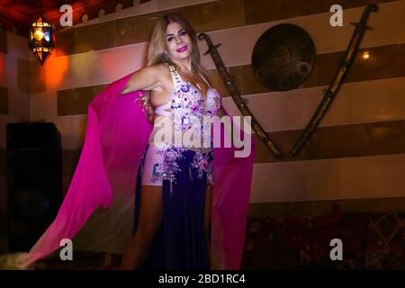 Beirut, Lebanon - May 30, 2017: Graceful mature woman of Lebanese origin performing belly dance with veil. Stock Photo