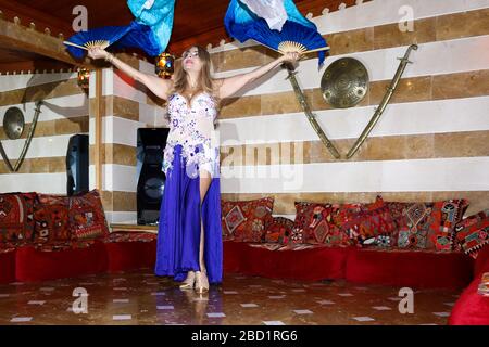 Beirut, Lebanon - May 30, 2017: Graceful mature woman of Lebanese origin performing belly dance with veil. Stock Photo