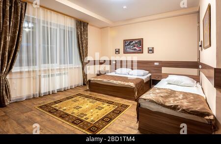 Moscow, Russia - July 6, 2019: Modern bedroom suite in hotel with two beds and carpet on the floor Stock Photo
