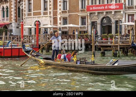 A couple taking a gondola ride in the late afternoon sunshine along the Grand Canal ,Venice,Italy Stock Photo