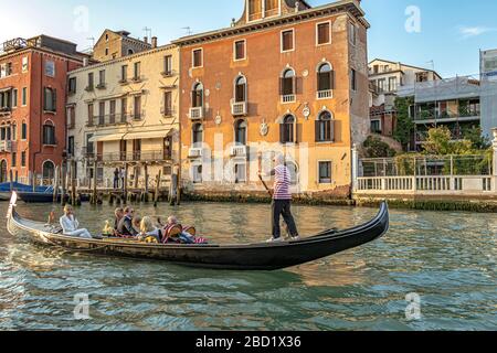 A wedding party taking a gondola ride in the late afternoon sunshine on The Grand Canal in Venice,Italy Stock Photo