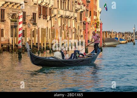 A wedding party taking a gondola ride in the late afternoon sunshine on The Grand Canal in Venice,Italy Stock Photo