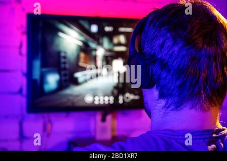 esports, gaming on pc - man playing online multiplayer shooter game. back view Stock Photo