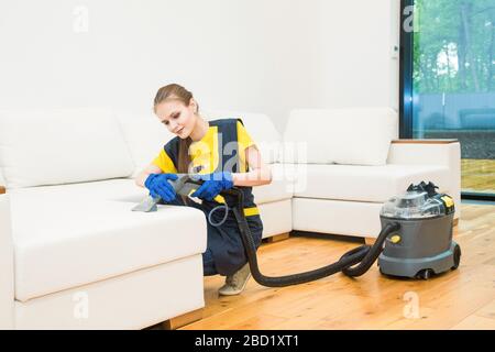 professional cleaning service. Two women in working uniform, in aprons. Two women in working uniform, in aprons, divide the cleaning of private house Stock Photo