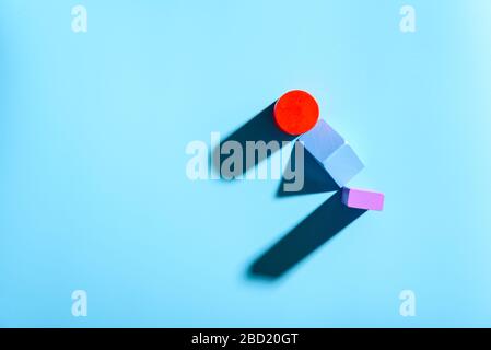 Blue background with red geometric figures casting shadows in a simple composition. Stock Photo