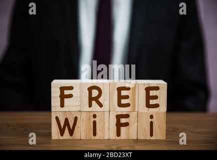 A sign saying Free Wifi for customers of hotels, retail and internet cafe in an internet, broadband connectivity background with copy space Stock Photo