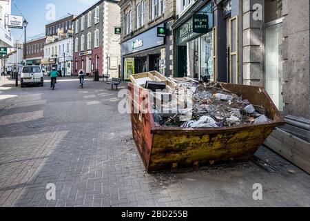 A building skip full of rubble in a street in Newquay Town centre in Cornwall. Stock Photo