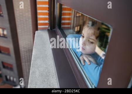 Sad girl looking out the window Stock Photo