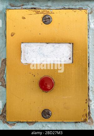 old doorbell plate with blank erased label and red button Stock Photo