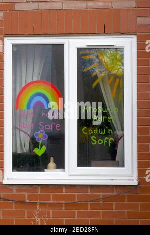 Childs drawing of a rainbow with thank you messages for NHS staff and key workers in a window of a house during government imposed lockdown in Wales Stock Photo