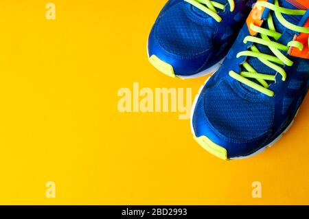 Blue sport shoes on yellow background, sport cloth, fitness at home Stock Photo