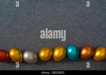 Elegant fashion background with border frame of decorative color metallic Easter eggs on textile background, copy space for text. Top view flat lay Stock Photo