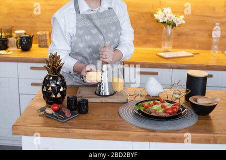 Woman preparing meal in the kitchen. Fresh vegetables on the plate. Stock Photo
