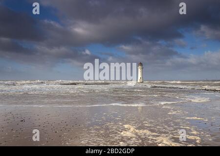 Foaming waves on beach at New Brighton Lighthouse, Perch Rock, New Brighton, Wirral Stock Photo