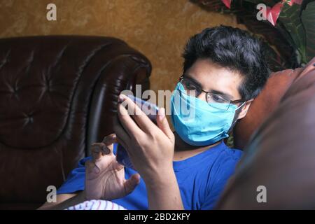 Man is wearing mask to prevent the infectious and using smart phone  Stock Photo