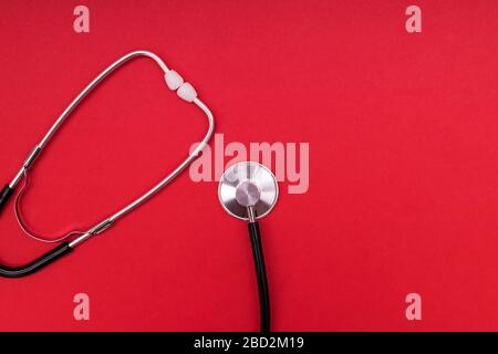 Stethoscope or phonendoscope isolated on red background. Stock Photo