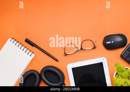 Modern workplace with tablet, earphones and other office related items Stock Photo