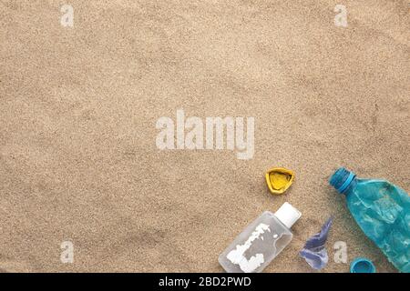 Plastic bottle lies on the beach and pollutes the sea. Spilled garbage on the beach. Empty used dirty plastic Stock Photo