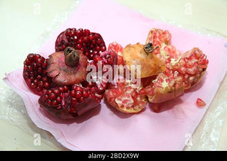 With clipping path. Full depth of field. Ripe pomegranate fruit on white isolated background. Juicy bright shiny pomegranate kernels isolated on white Stock Photo