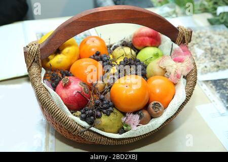 basket are pomegranates, dates, pears, quinces, mashed potatoes, black hawthorn. Stock Photo