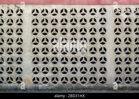 Decorative outdoor wall made of openwork concrete panels or blocks with a geometric repeating pattern as s background. Architectural retro style. Stock Photo