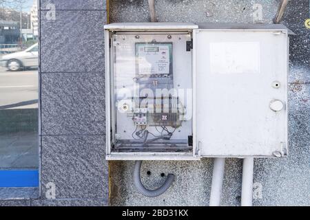 Varna, Bulgaria, April 06, 2020. Open distribution switchboard with electric meter box on a outdoor wall of the building. View from the street. Stock Photo