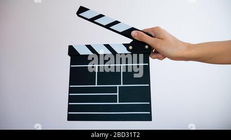 Hand holding empty film making clapperboard isolated on white background. Stock Photo
