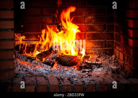 Fire flame, burning wood at the fireplace. Firewood log in the fire chimney, closeup. Stock Photo