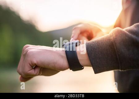 Man in nature using smartwatch app. Close-up hands Stock Photo