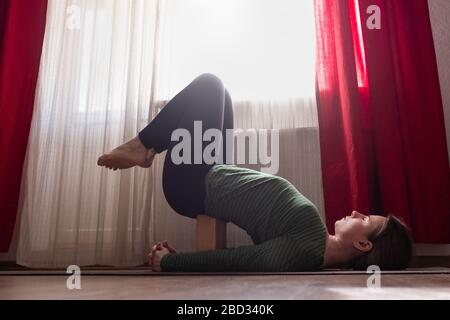 Young woman practicing yoga, doing Viparita Karani exercise, upside down pose Stock Photo