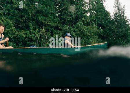 A young girl rides in a canoe with her dad on Lost Lake in Oregon. Stock Photo