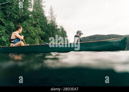 A young girl rides in a canoe with her dad on Lost Lake in Oregon. Stock Photo