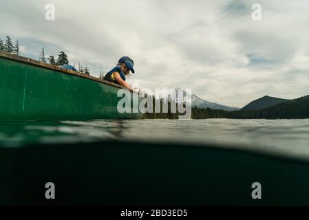 A young girl rides in a canoe with her dad on Lost Lake in Oregon. Stock Photo